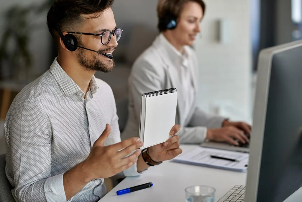 happy customer service representative using computer having video call with clients while working call center